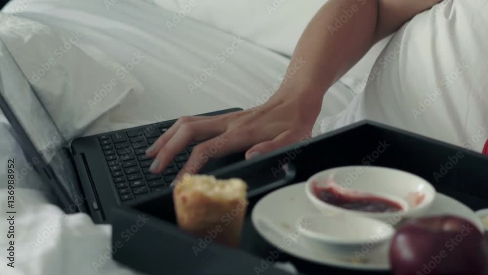 Female hands using laptop during breakfast on bed at home
Female hands using laptop during breakfast on bed at home