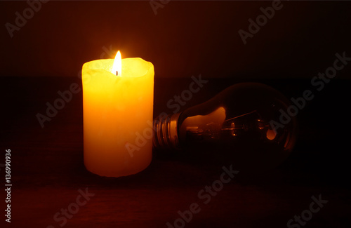 Obraz na płótnie Burning candle and lamp on desktop in darkness (no electricity). Power outage. w salonie