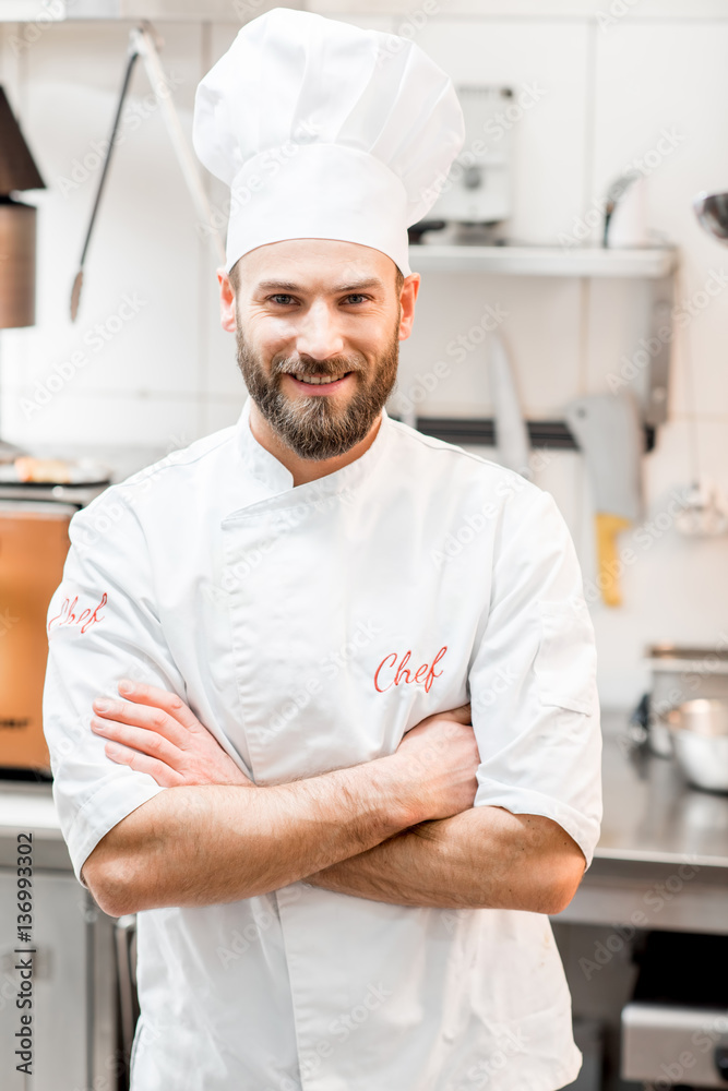Portrait of chef cook in uniform at the restaurant kitchen