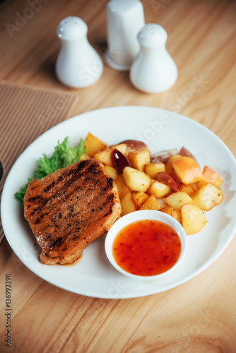Steak with crispy golden fries and tomato spicy sauce