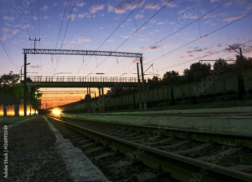 The train at sunset approaches the station
