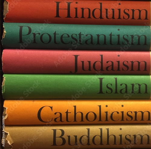 Colorful stack of religious books in Hinduism, Protestantism, Judiasm, Islam, Catholicism, Buddhism