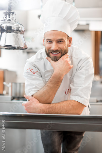 Portrait of a chef cook in uniform at the restaurant kitchen