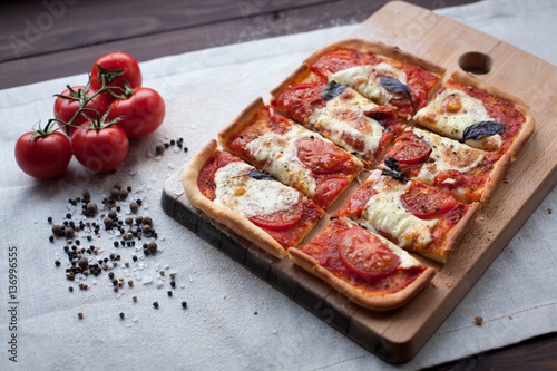 rustic italian pizza with mozzarella, cheese and basil leaves photo