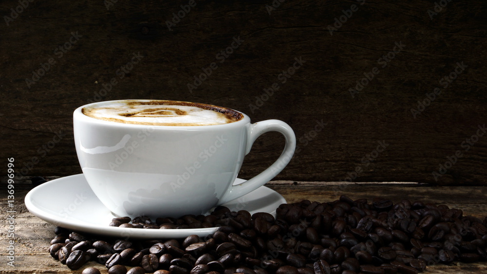 Cappuccino coffee with love and hearts. A cup of latte, cappuccino or espresso coffee with milk put on a wood table with dark roasting coffee beans. Drawing the foam milk on top. Cappuccino coffee with love and hearts. A cup of latte, cappuccino or espresso coffee with milk put on a wood table with dark roasting coffee beans. Drawing the foam milk on top.