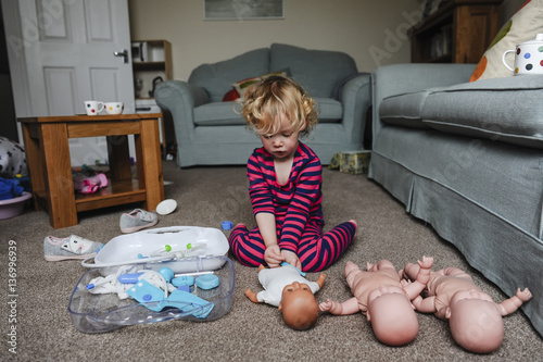 Girl playing with dolls at home photo