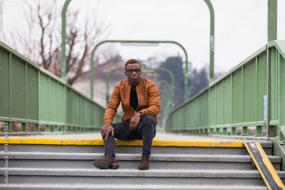 Handsome black man sitting on stairs