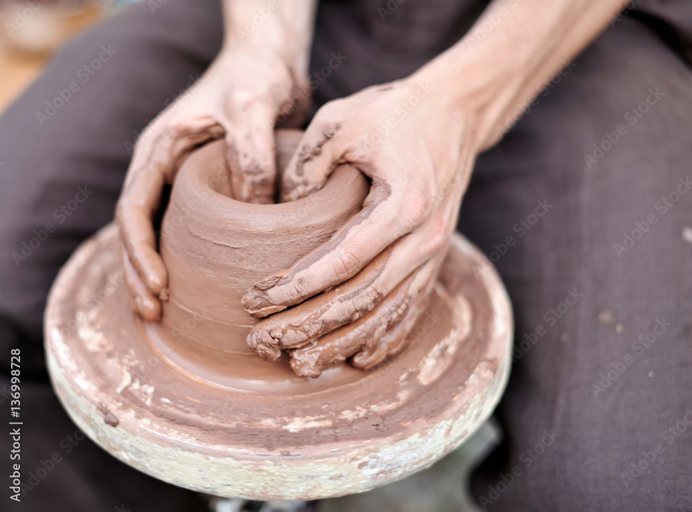 Potter molds clay vase. Dirty hands close-up making ceramic products.