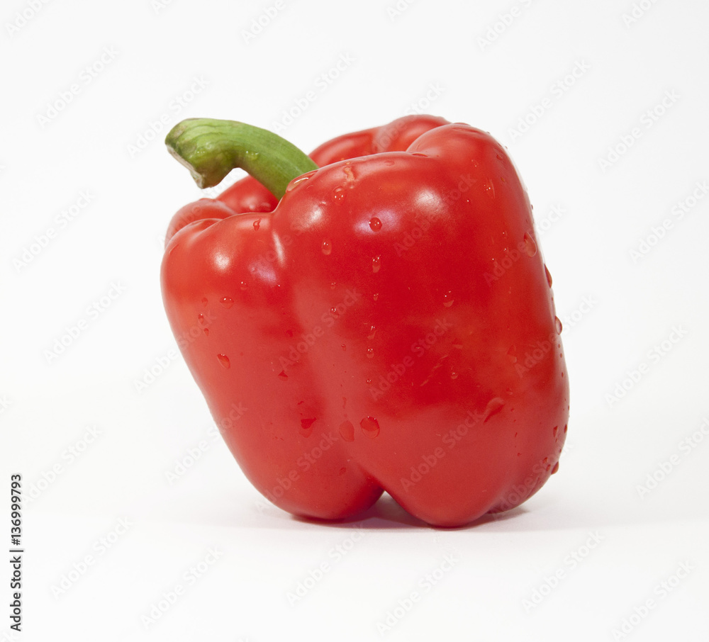 Single red pepper with green stem against a white background Single red pepper with green stem against a white background