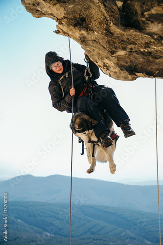 the dog pulls on the rope in a mountain