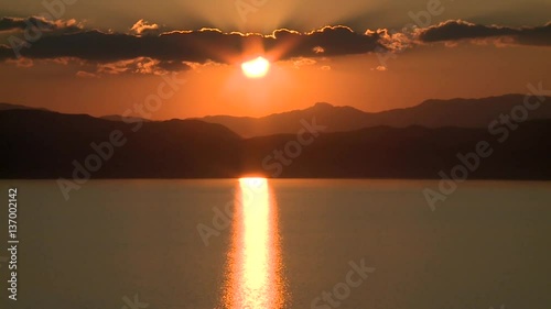 Sunset behind hills and lake