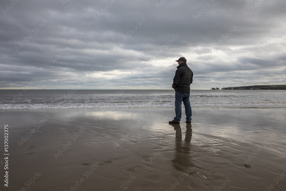 man in colder weather looking out to sea man in colder weather looking out to sea