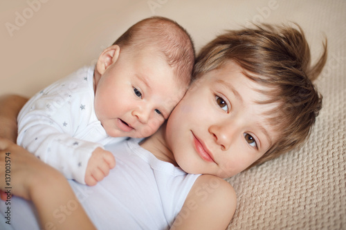older brother hugging newborn baby