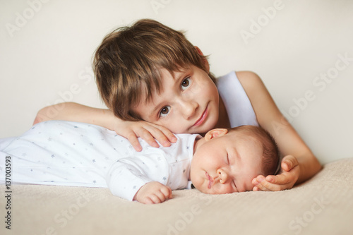 older brother hugging newborn baby