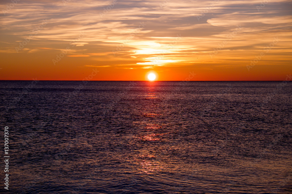 Fototapeta premium sunset casting long highlight over sea