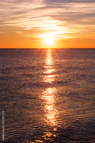 sunset casting long highlight over sea