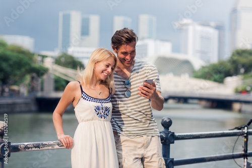 Young couple looking at something on a phone while touring a foreign city
