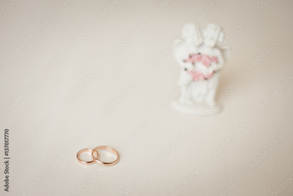Wedding rings and Cupid statuette, wedding accessories Wedding rings and Cupid statuette, wedding accessories