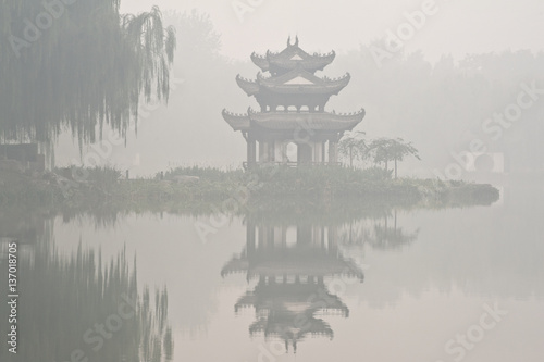 A chinese pavilion in fog