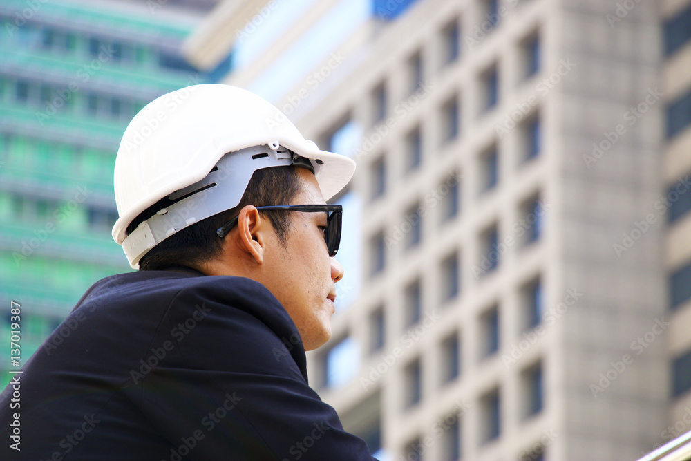 Engineer man is looking at building.