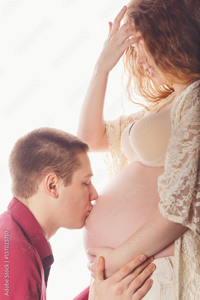 Husband kissing belly of a pregnant girl. Happiness and love in the family. Husband kissing belly of a pregnant girl. Happiness and love in the family.