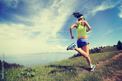 healthy lifestyle woman trail runner running on mountain peak