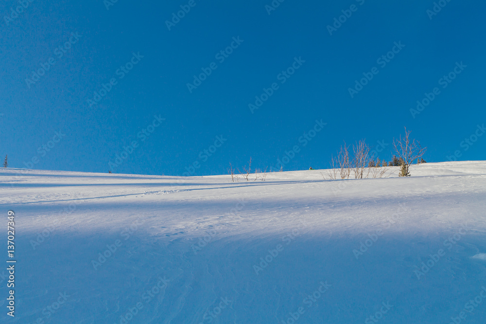 Snow slope on a blue sky background.