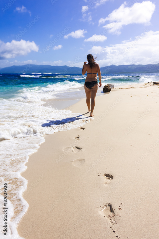 Young woman walking on the seaside on the sand Young woman walking on the seaside on the sand