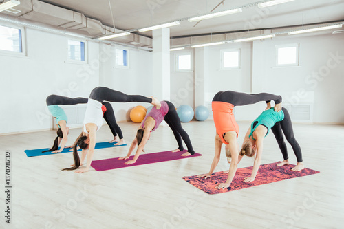 women are practicing yoga exercises in the studio. yoga