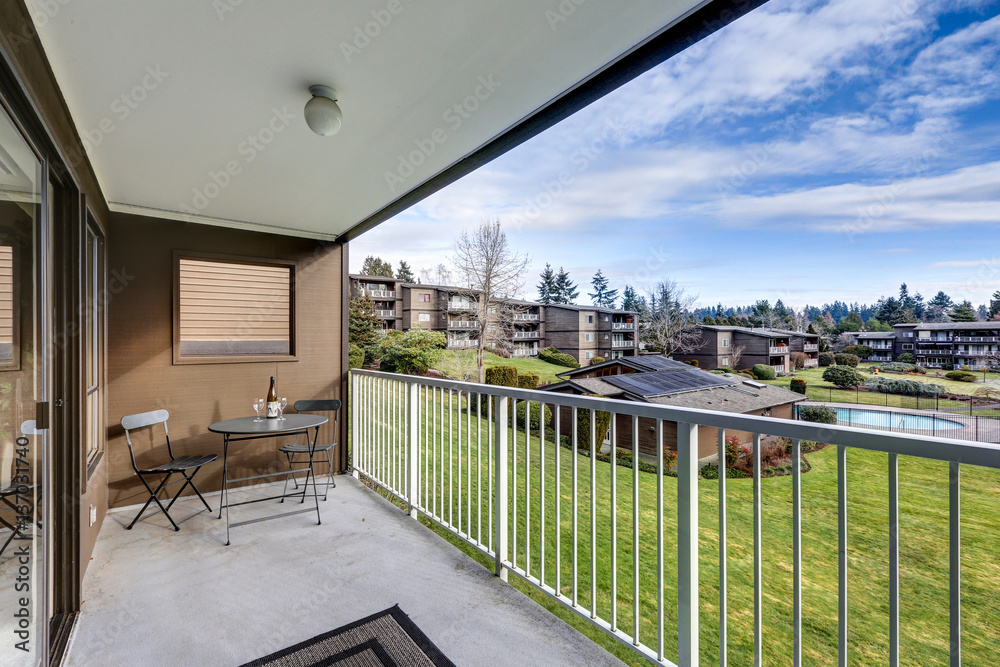 Fototapeta premium View from apartment balcony of grassy hill and pool