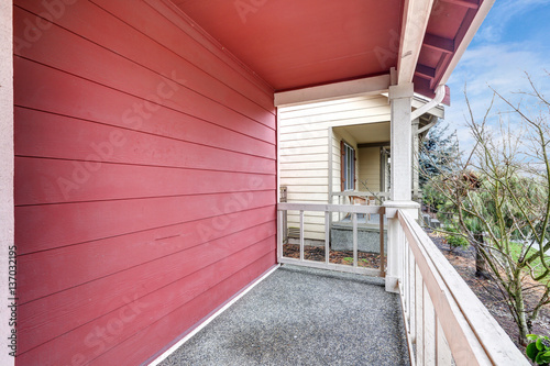 Covered red front porch with railings