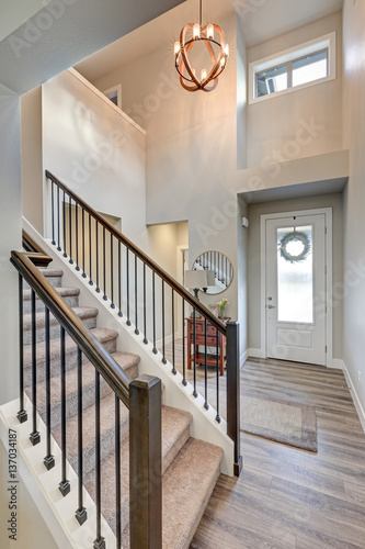 Grey foyer with high ceiling over laminate flooring 