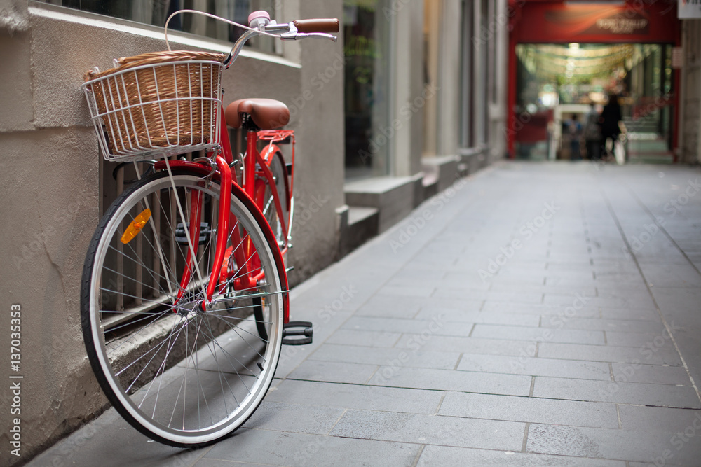 A red bicycle parked in a laneway