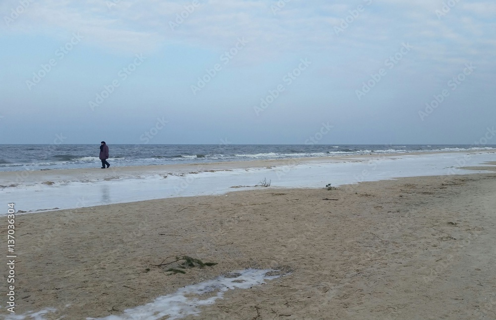 Einsame Spaziergängerin am winterlichen Ostseestrand