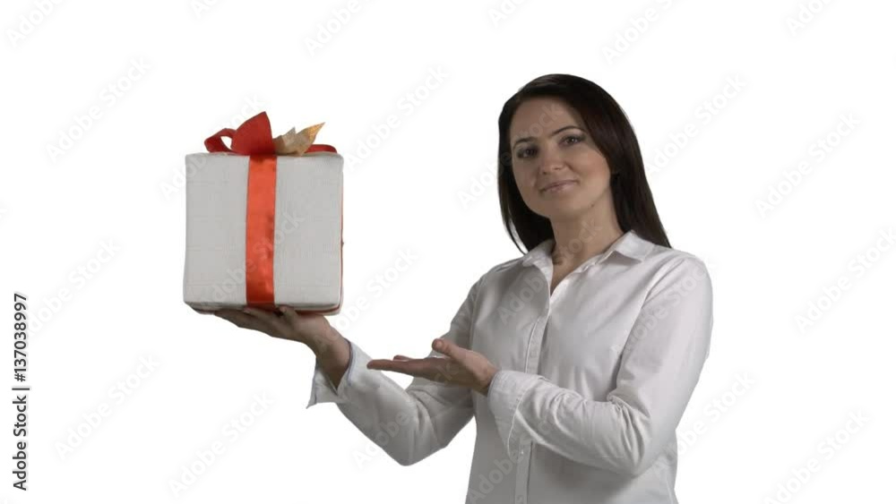 Business woman holding and showing red white Christmas present gift box looking directly at the camera on white background. 4k footage PNG with alpha channel Business woman holding and showing red white Christmas present gift box looking directly at the camera on white background. 4k footage PNG with alpha channel