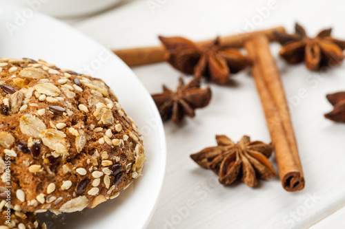 Close-up shot of homemade oatmeal cookies in a white ceramic plate with cinnamon and star anise