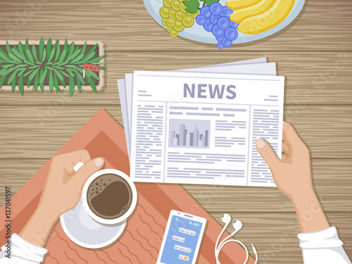 Man reading the latest news at breakfast. Human hands holding coffee and newspaper, phone with messages, headphones, fruit, pot. Good start in the morning before beginning the working day. Top view.