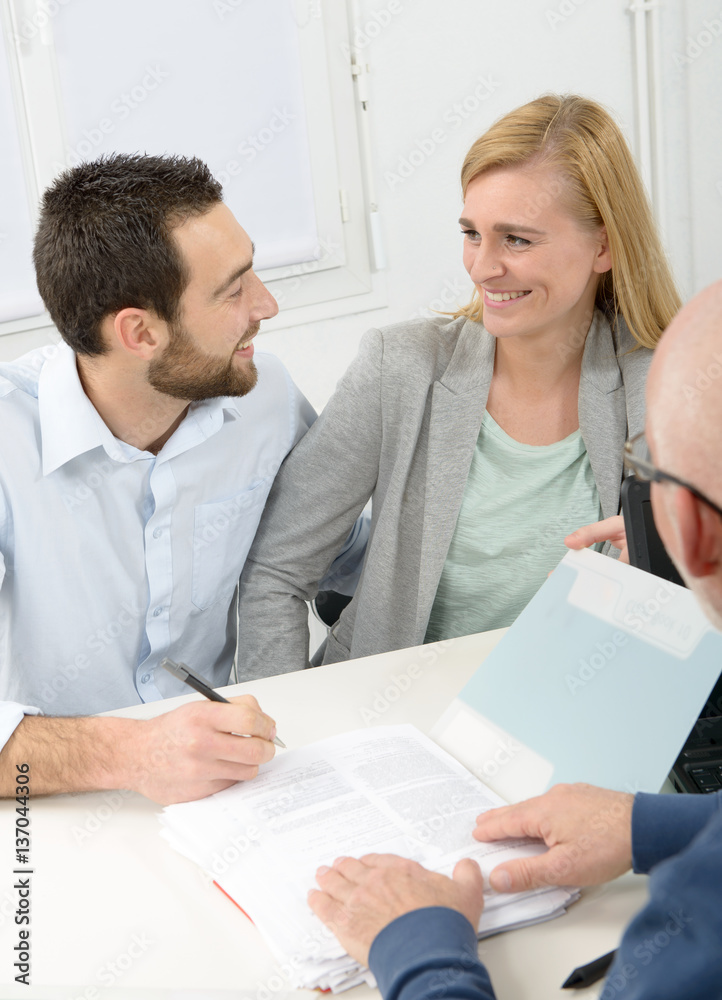young couple signing property purchase contract young couple signing property purchase contract