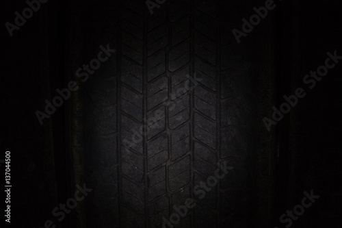 Car tires in a row on a shelf tire. Close-up in dark.
