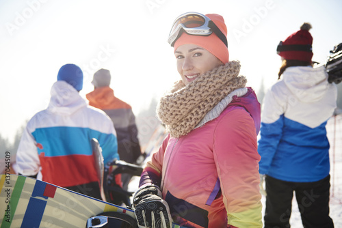 Woman in ski clothes with friends on the background.