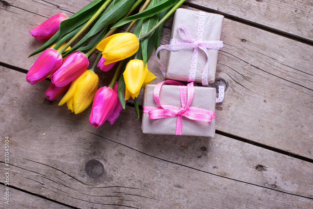 Bright tulips flowers and boxes with presents on vintage wooden Bright tulips flowers and boxes with presents on vintage wooden