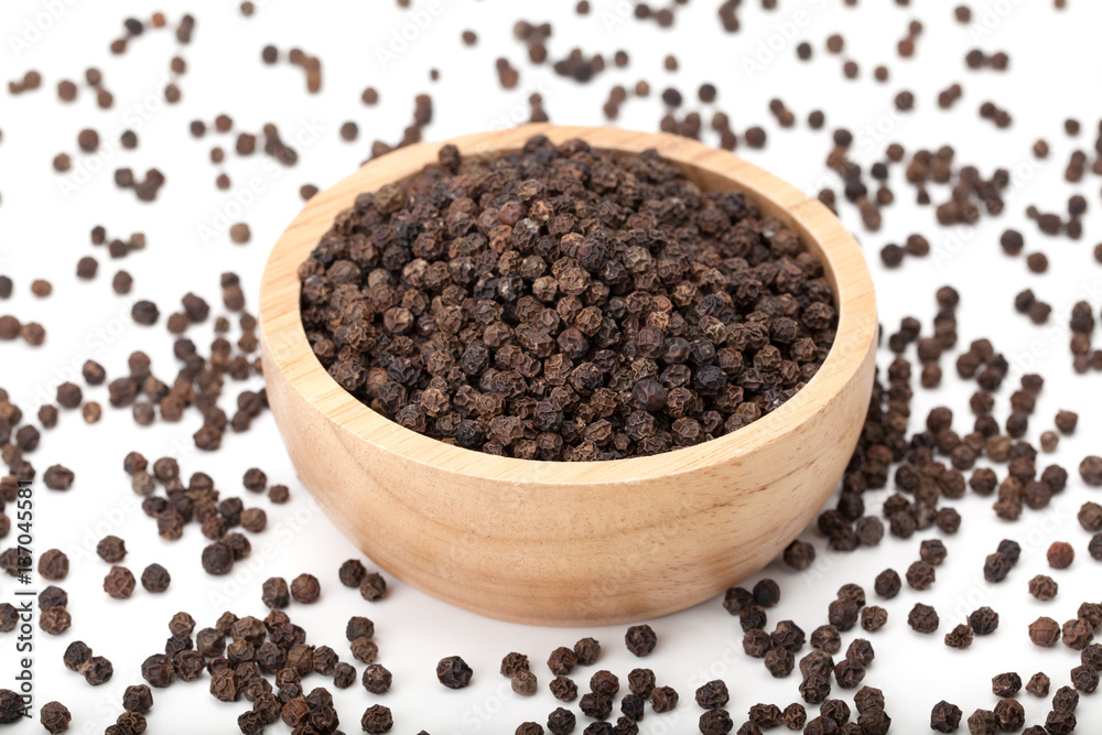 black peppercorns in wooden bowl black peppercorns in wooden bowl