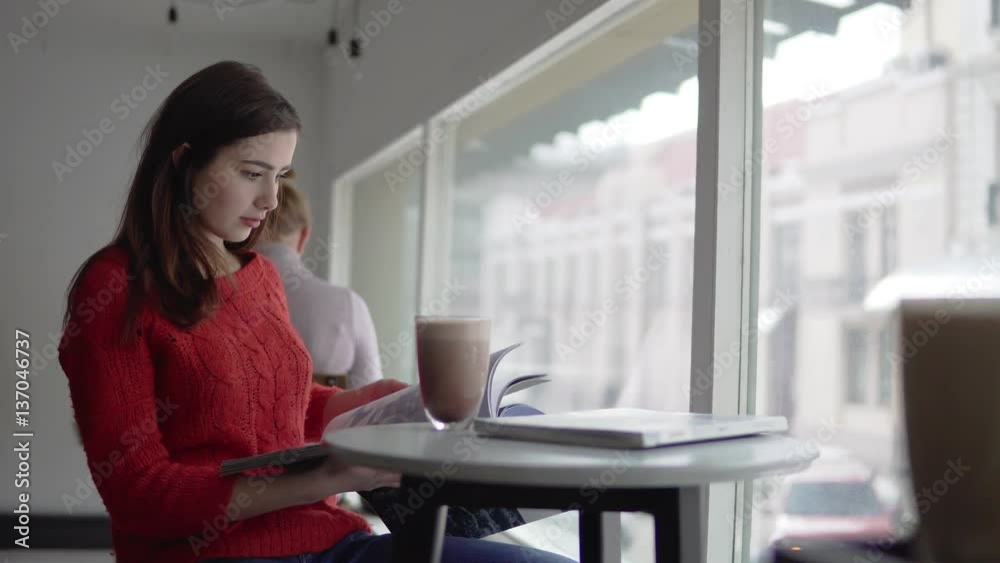 Beautiful woman reading newspaper, drinking coffee in cafe Beautiful woman reading newspaper, drinking coffee in cafe