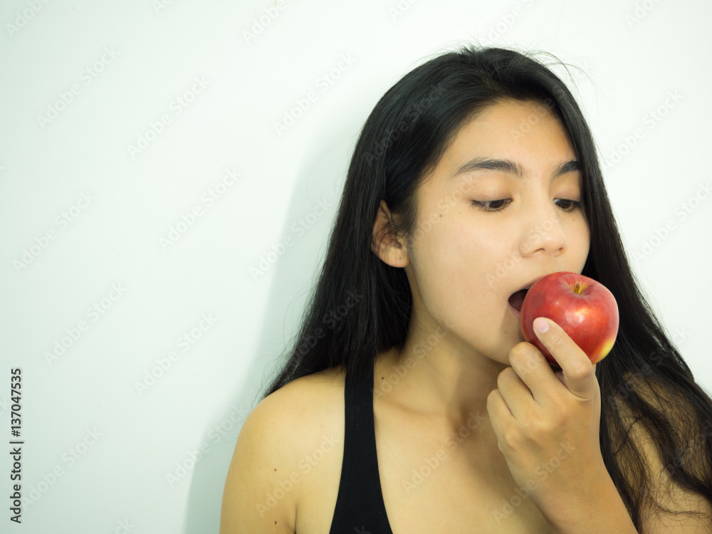 Asian woman eating red apple on white background Asian woman eating red apple on white background