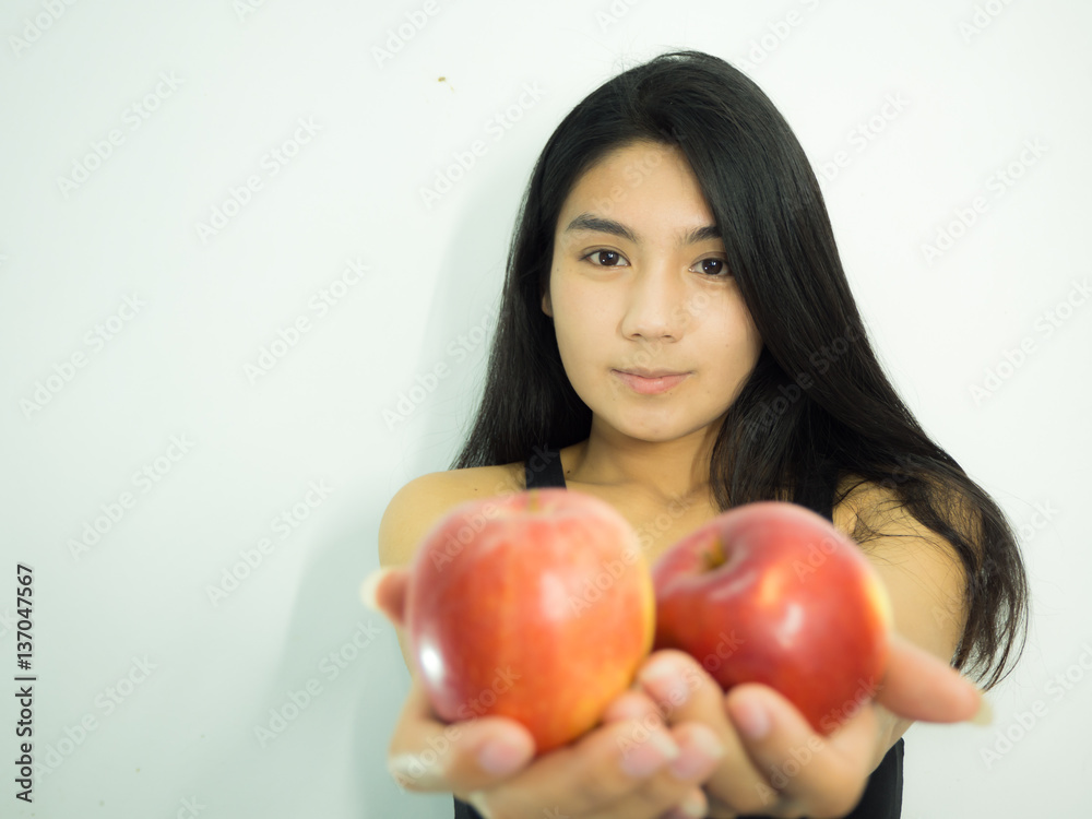 Asian woman holding red apple on white background, focus on her face, take apple on her side Asian woman holding red apple on white background, focus on her face, take apple on her side