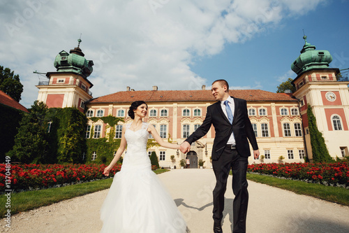 Newlyweds walking around castle in Łańcut.