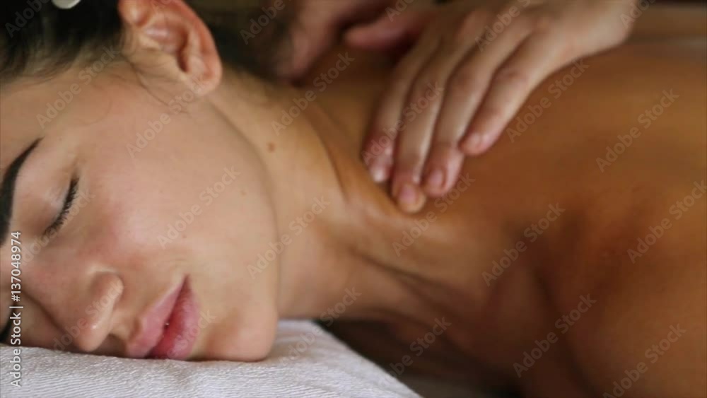 Relaxed Woman Receiving A Back Massage At Health Spa. caucasian young woman lying on massage table having a massage with a oil. Body treatment with massage oil at spa center. Relaxed Woman Receiving A Back Massage At Health Spa. caucasian young woman lying on massage table having a massage with a oil. Body treatment with massage oil at spa center.