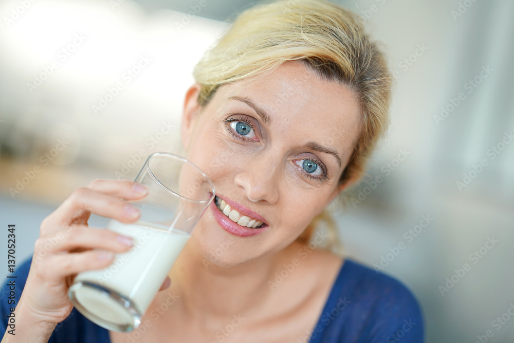 Portrait of blond mature woman drinking milk from glass Portrait of blond mature woman drinking milk from glass