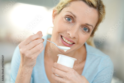 Portrait of blond woman eating yogurt
