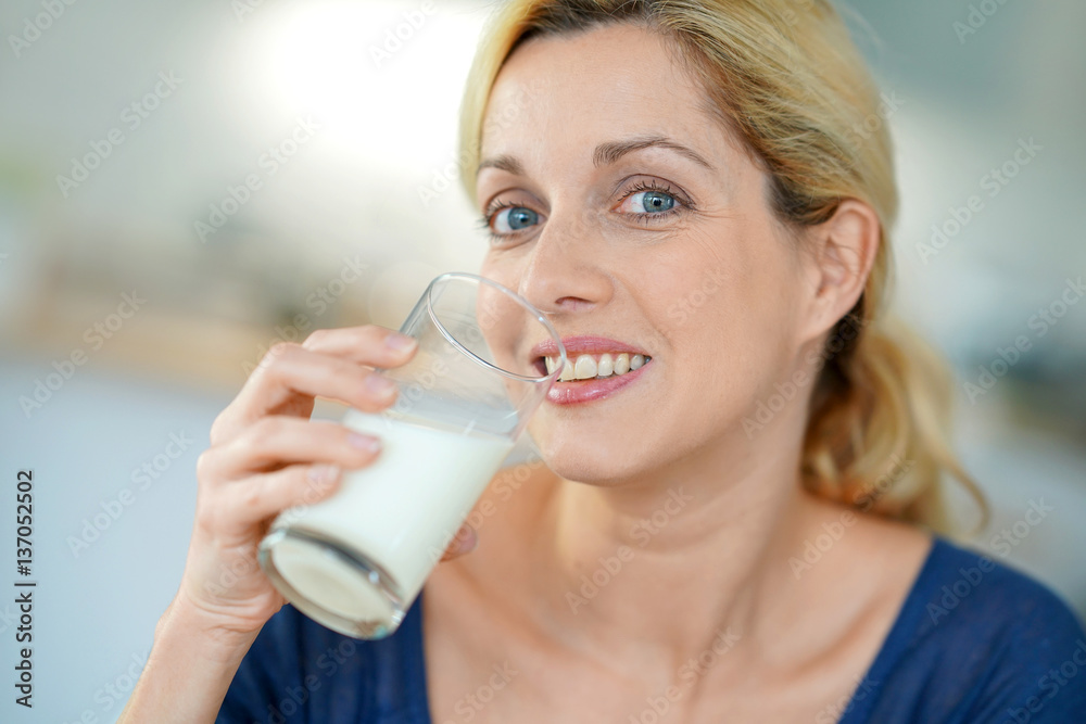 Portrait of blond mature woman drinking milk from glass Portrait of blond mature woman drinking milk from glass